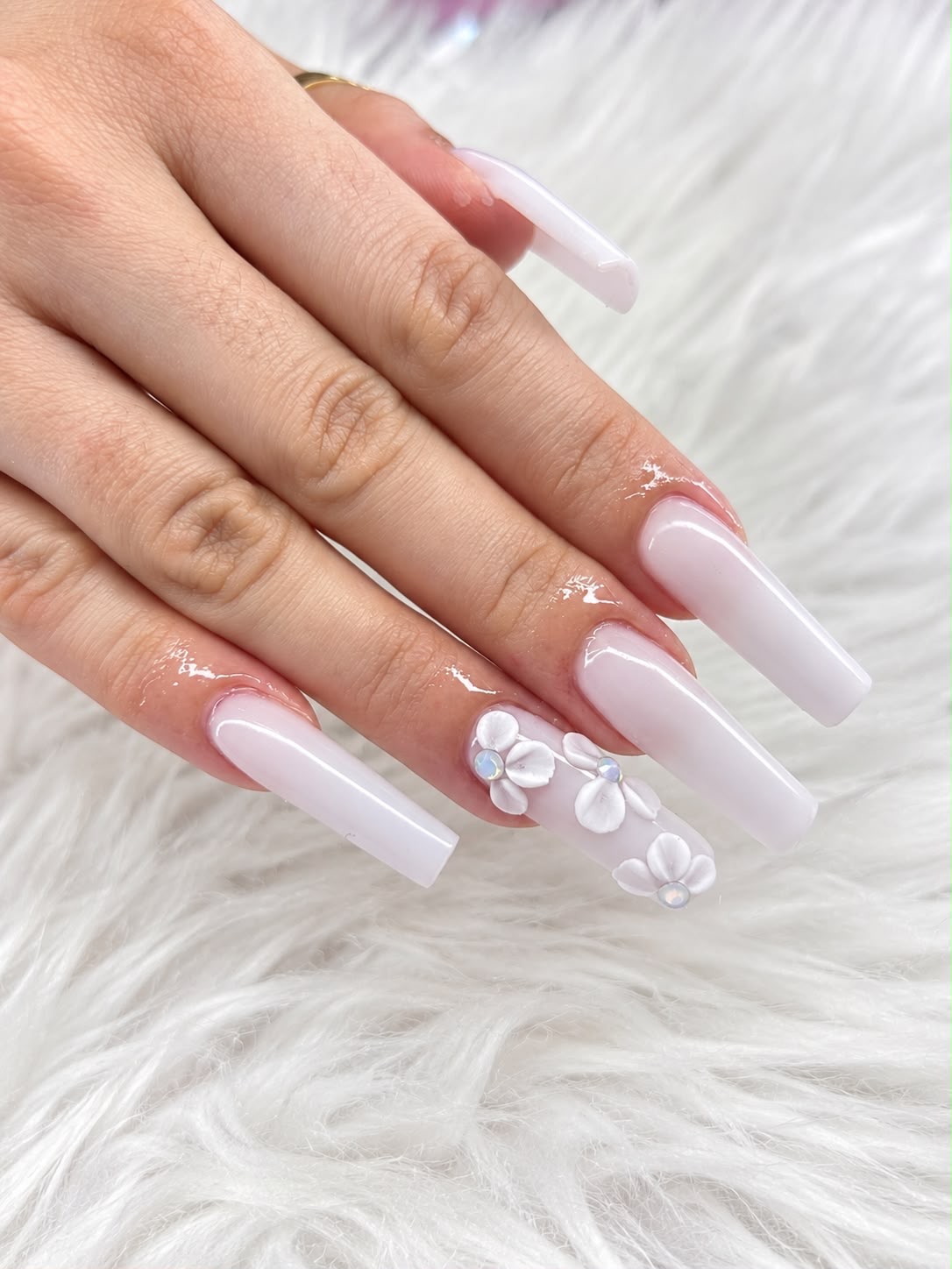 Uñas largas blancas con flores en relieve