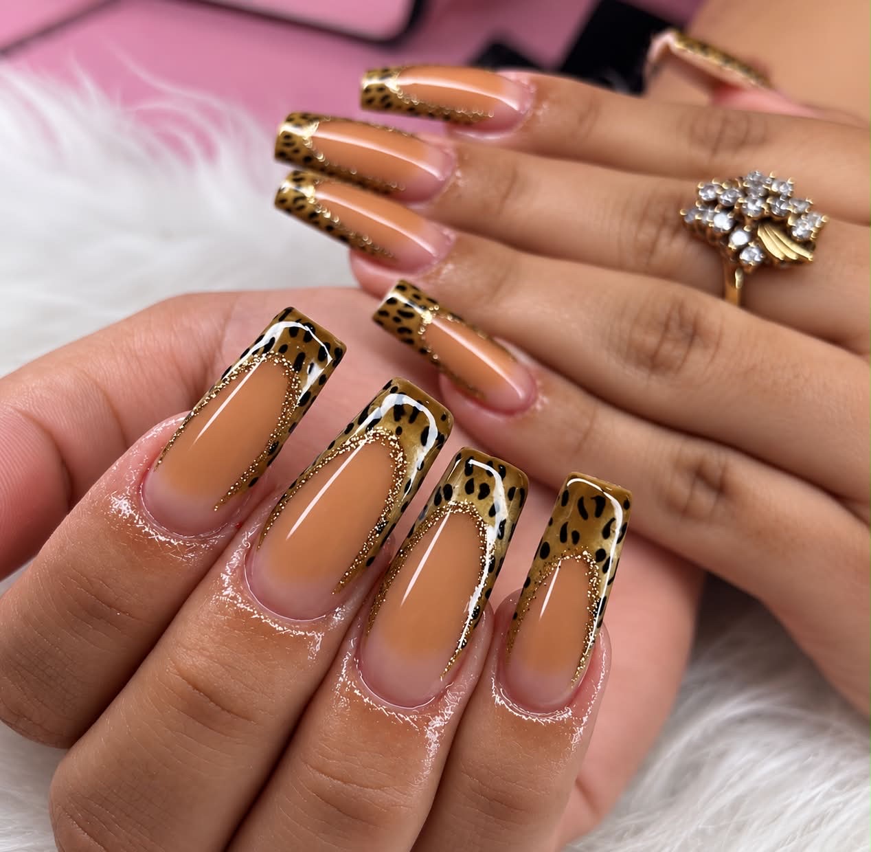 Uñas estilo francés con animal print y brillo dorado