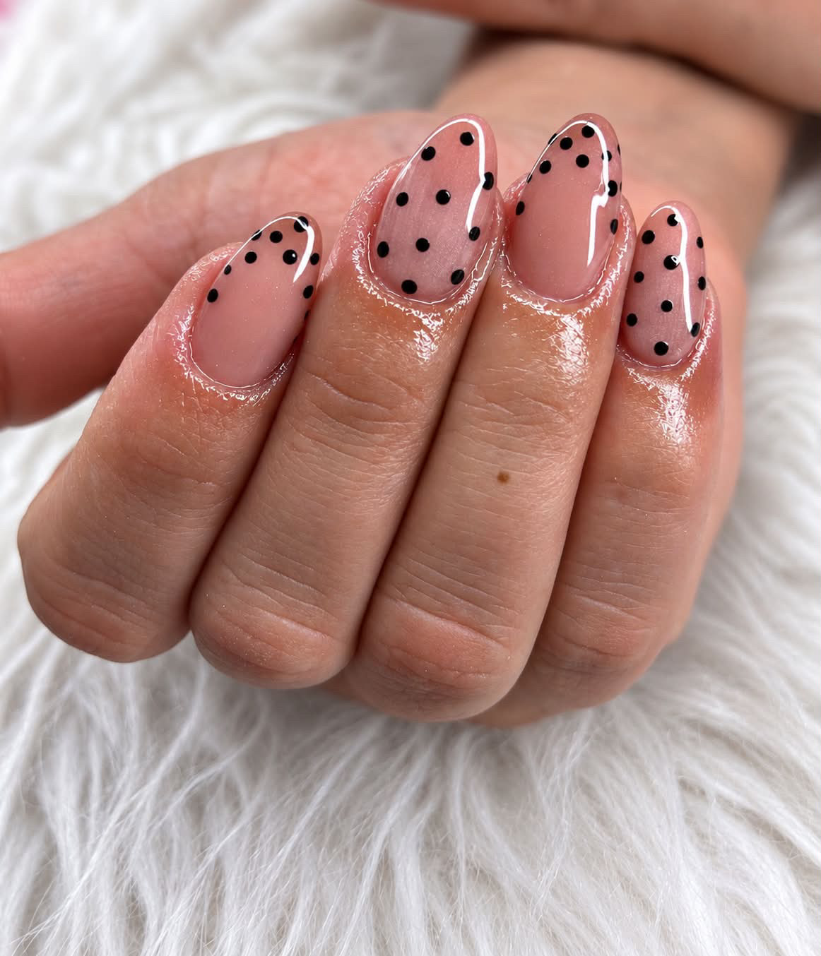 Uñas rosadas brillantes con puntos negros